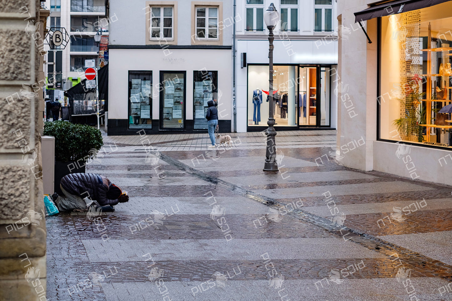 Rainy day street scene in Luxembourg City with contrasting realities