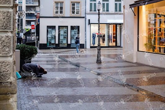 Rainy day street scene in Luxembourg City with contrasting realities