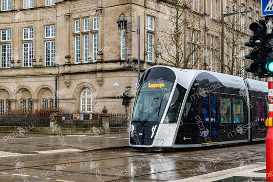 Modern tram passing historical building in Luxembourg city