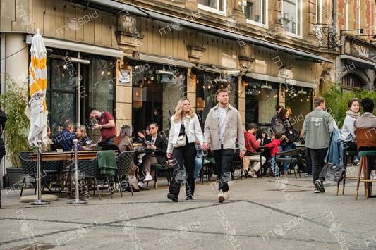 Couple walking past busy terrace café in Luxembourg city