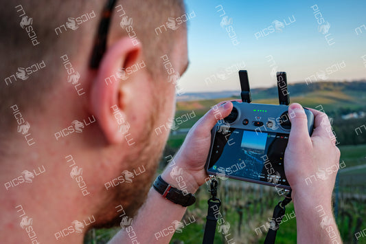Operating drone over Remich vineyards at sunset