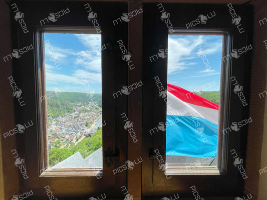 View of Vianden and Luxembourg flag from castle window