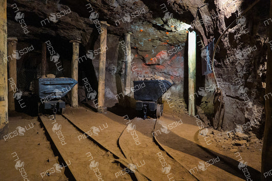 Historic underground mine tunnel with mining carts and timber supports