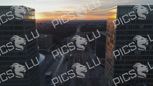 Aerial drone flight between glass skyscrapers over Avenue John F. Kennedy at sunset, Luxembourg.